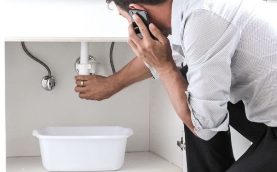 bigstock-man-calling-plumber-in-front-o-361105207_1_621x621